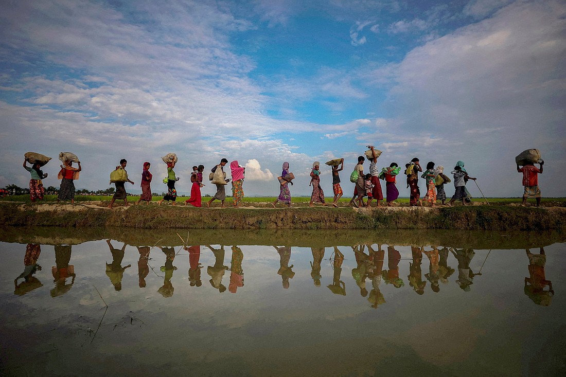 Rohingya refugees are reflected in rain water along an embankment next to paddy fields after fleeing from Myanmar into Palang Khali, near Cox's Bazar, Bangladesh Nov. 2, 2017. President Donald Trump said in a series of social media posts Nov. 27, 2025, that he will "permanently pause" all immigration from what he called "Third World Countries." (OSV News photo/Hannah McKay, Reuters)