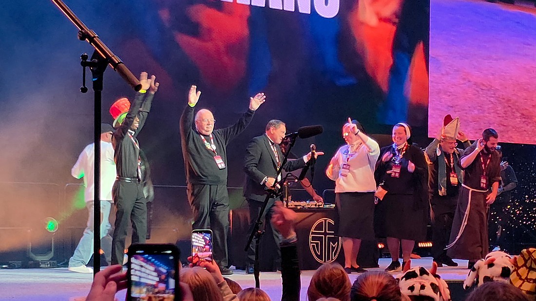 Father Stephen Sansevere, second from left, gets into the groove during the NCYC. Father Sansevere accompanied members of the youth group from St. James Parish, Pennington. Facebook photo