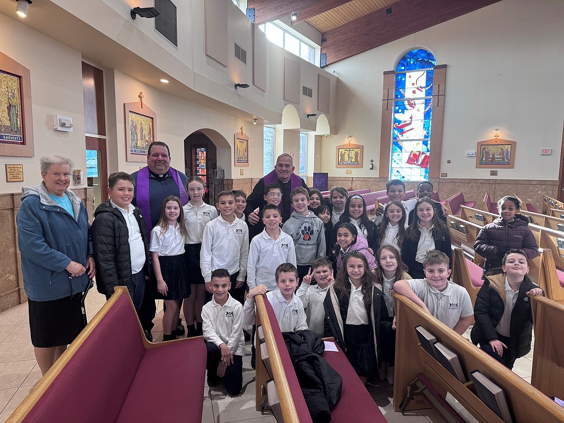 Fourth graders in St. Gregory the Great Academy, Hamilton Square, pose for a photo with Bishop O'Connell and Father Hall Dec. 10. The Bishop and a number of priests visited the school and celebrated the Sacrament of Reconciliation. At left is the fourth grade class teacher, Franciscan Sister Natalie Panas. Staff photo