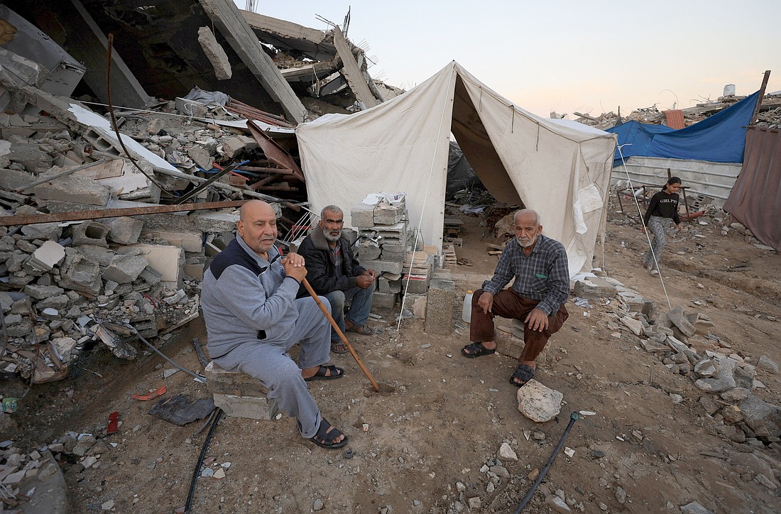 Palestinians sit near a tent that stands next to debris in Gaza City Nov. 17, 2025, amid a ceasefire between Israel and Hamas. (OSV News photo/Dawoud Abu Alkas, Reuters)