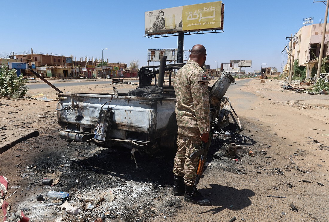 A Sudanese army soldier stands next to a destroyed combat vehicle as Sudan's army retakes ground and some displaced residents return to ravaged capital in the state of Khartoum Sudan March 26, 2025. Drones the attacked a kindergarten and hospital in the town of Kalogi, Dec. 4, killing more than 100 people, including children. (OSV News photo/El Tayeb Siddig, Reuters)