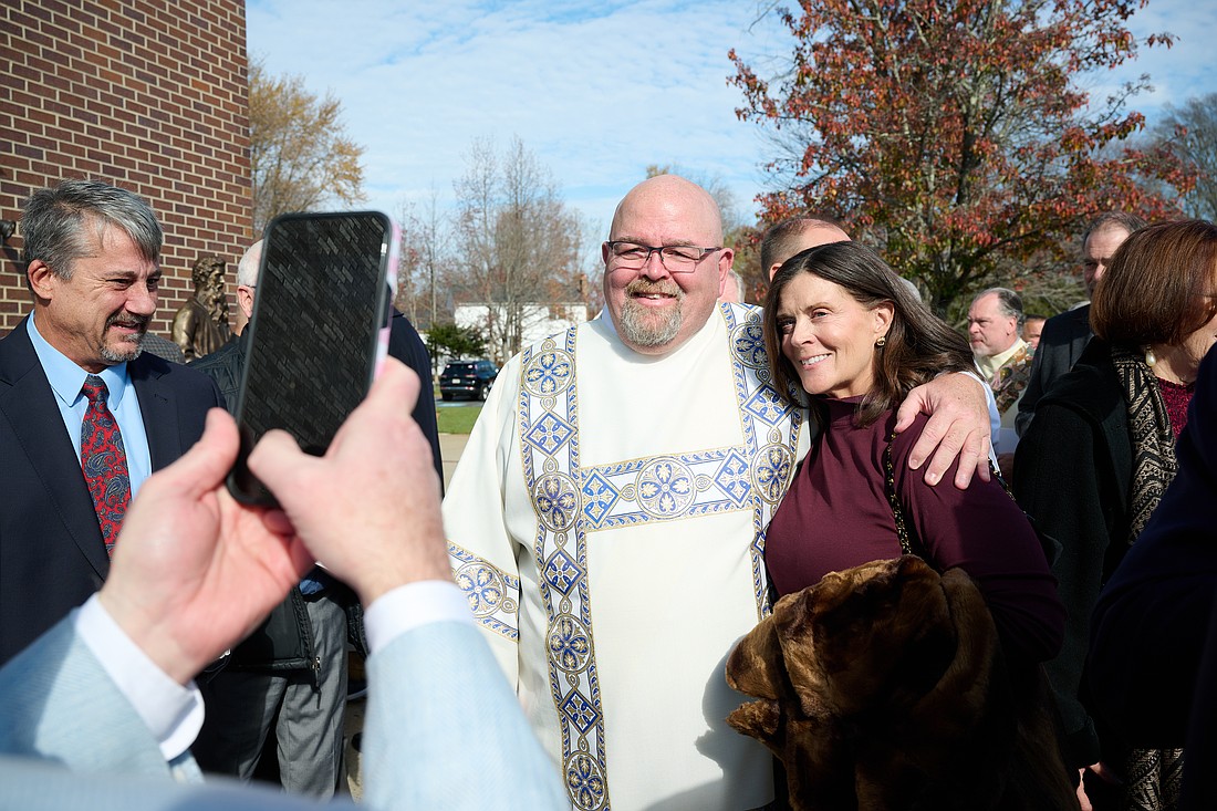 Cell phones were busy on Ordination Day, capturing highlights such as this where Deacon de Poortre greets loved ones. Mike Ehrmann photo