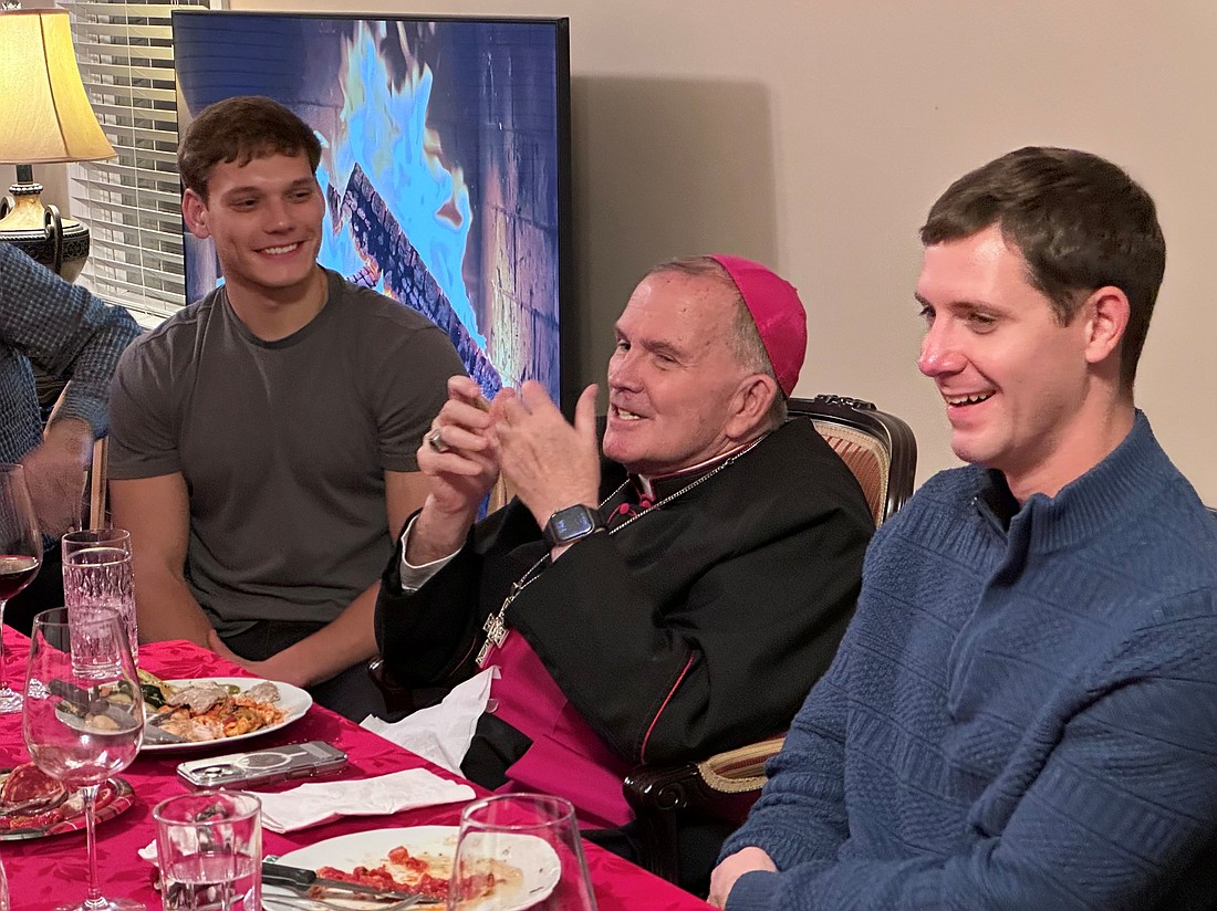 Bishop David M. O’Connell, C.M., shares conversation during a dinner for men discerning a vocation to the priesthood following Mass Dec. 13. The dinner was held at the residence of Father Chris Colavito on the campus of The College of New Jersey, Ewing. Father Colavito serves as director of vocations and the diaconate formation program and as chaplain of the college. Courtesy photo