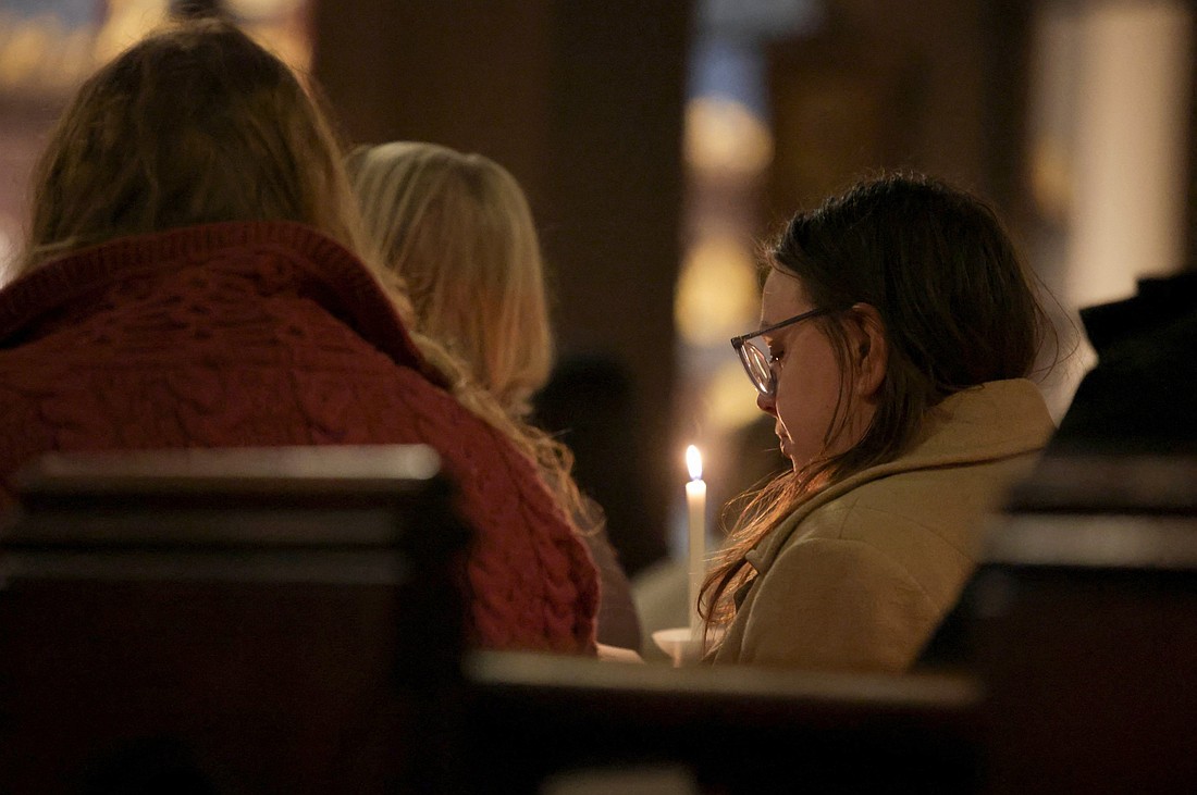 A young woman holds a candle during a community healing service at St. Stephen's Episcopal Church in Providence, R.I., Dec. 16, 2025, as the manhunt continued for the gunman, following a mass shooting at Brown University. The Dec. 13 shooting left two students dead and nine others injured at the Ivy League school, where classes and exams have been canceled. (OSV News photo/Taylor Coester, Reuters)