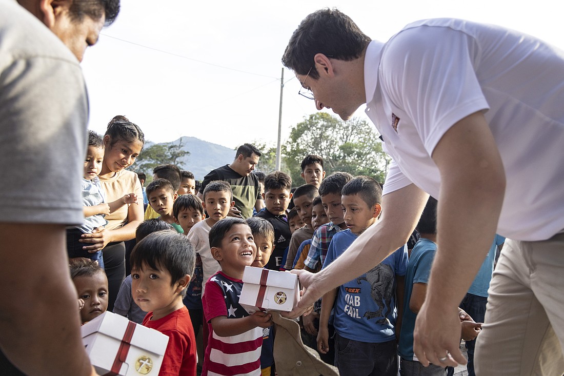 David Henrie, actor, gives a gift to a child during a mission trip to the Diocese of Santa Rosa de Lima, Guatemala, for Cross Catholic Outreach delivering a Box of Joy Nov. 20, 2024. Box of Joy gifts are Christmas gifts sent to children in developing countries and are filled with toys, clothing, school supplies and other items. (CNS photo/courtesy of Cross Catholic Outreach)