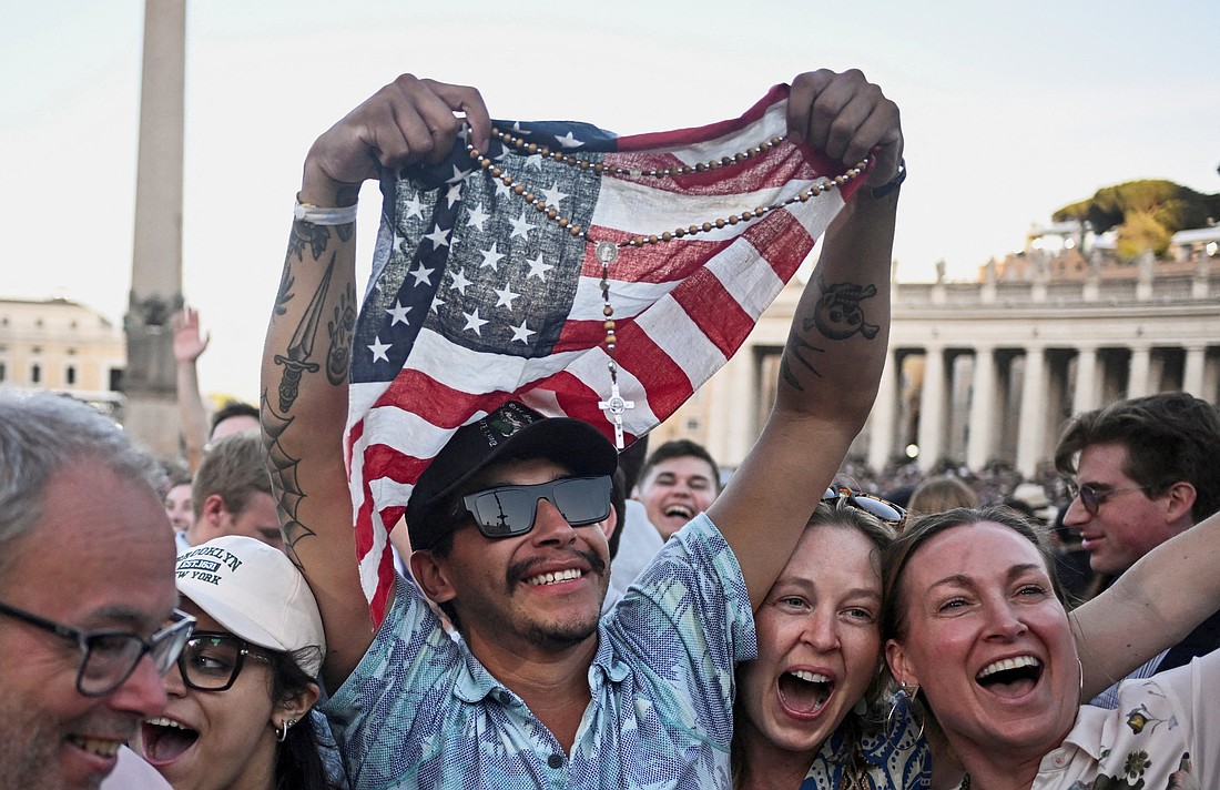 A man holding a rosary and U.S. flag reacts as Cardinal Robert Francis Prevost, who has chosen the papal name Leo XIV, appears on the central balcony of St. Peter's Basilica at the Vatican May 8, 2025, following his election during the conclave. He is the first American pope in history. (OSV News photo/Dylan Martinez, Reuters)