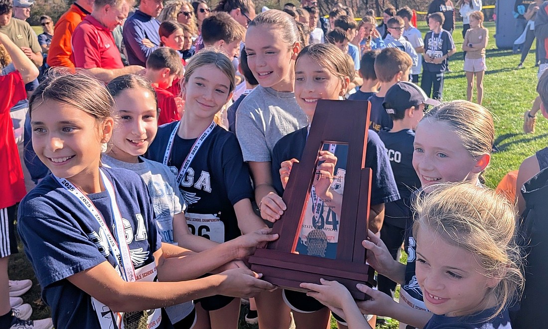 The St. Gregory the Great JV cross country team proudly displays its trophy after winning the New Jersey Catholic Elementary School state championship in Basking Ridge in November. Courtesy photo