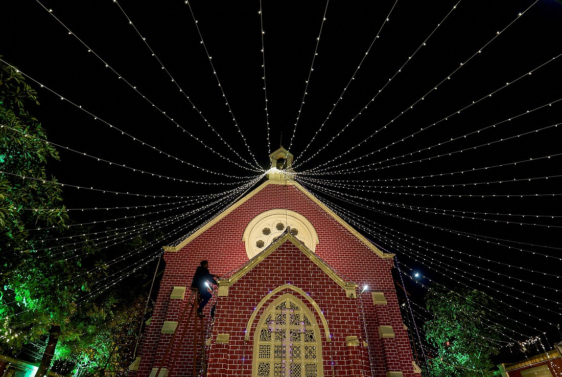 A man installs decorative lights on a church on Christmas Eve in Ahmedabad, India, Dec. 24, 2024. (OSV News photo/Amit Dave, Reuters)
