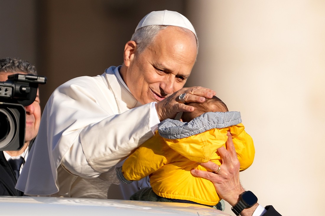 Pope Leo XIV greets a child from the popemobile as he rides around St. Peter's Square at the Vatican before his weekly general audience Dec. 31, 2025. (CNS photo/Lola Gomez)