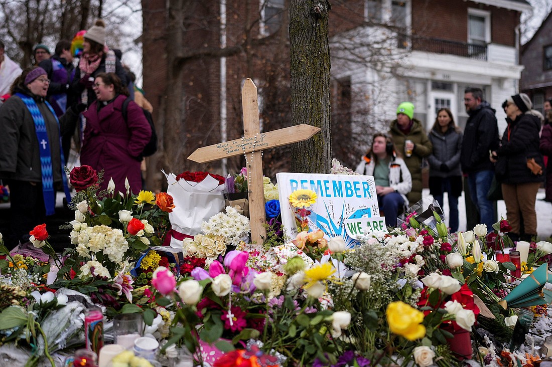 A rosary is draped over a cross as people gather by a makeshift memorial in Minneapolis Jan. 8, 2026, at the scene of the fatal shooting of Renee Nicole Good by a U.S. Immigration and Customs Enforcement agent. The 37-year-old woman was shot in her car Jan. 7, according to local and federal officials. (OSV News photo/Tim Evans, Reuters)