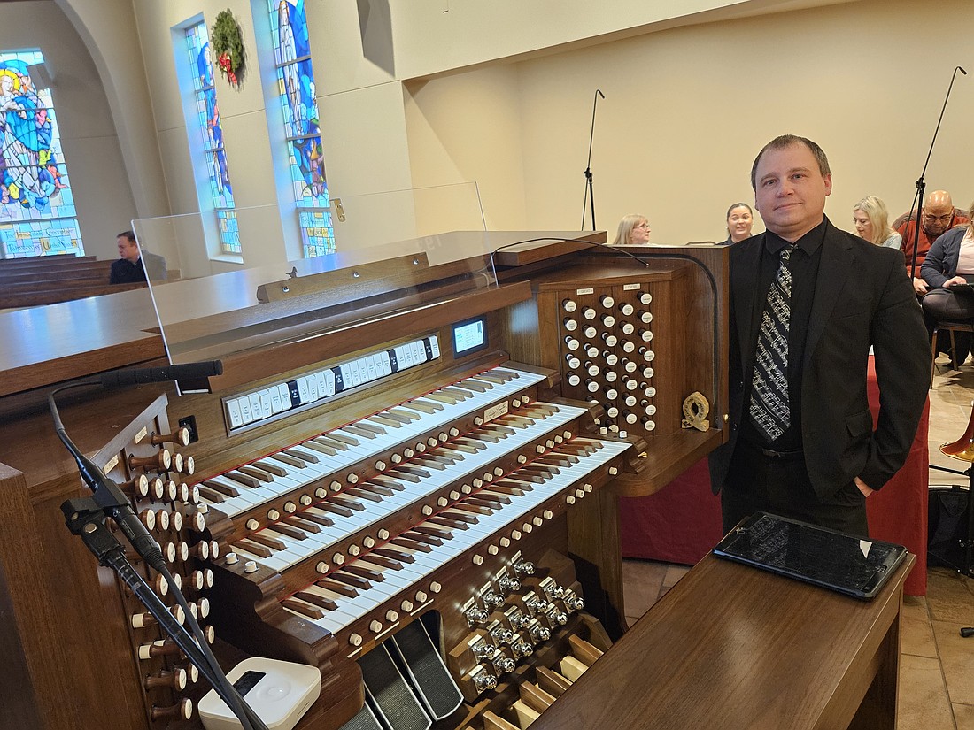 Andrew Macirowski, Andrew Macirowski, pastoral coordinator for worship and music and principal organist in St. Mary Parish, Colts Neck, is pictured next to the organ that was blessed during a Jan. 3 Mass. Mary Stadnyk photo