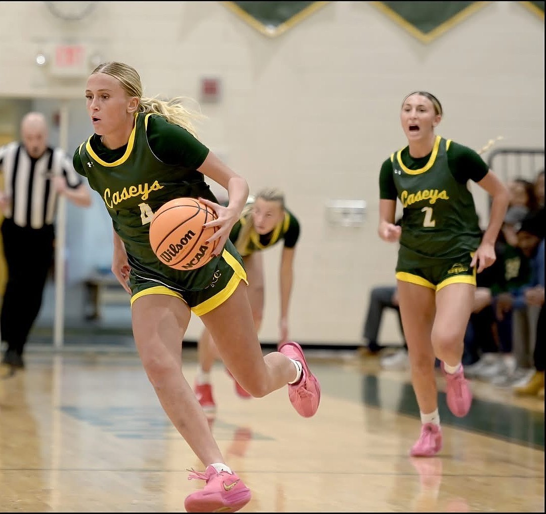 Katie Liggio brings the ball upcourt while her twin sister Tessa trails the play shouting out instructions. Photo by Jack Flaherty