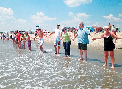 Hands of hope stretch across the sand