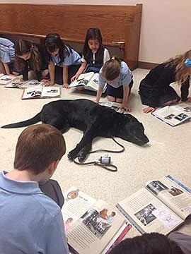 Paws and Pages -- Students in St. Dominic School get furry companions for reading practice  